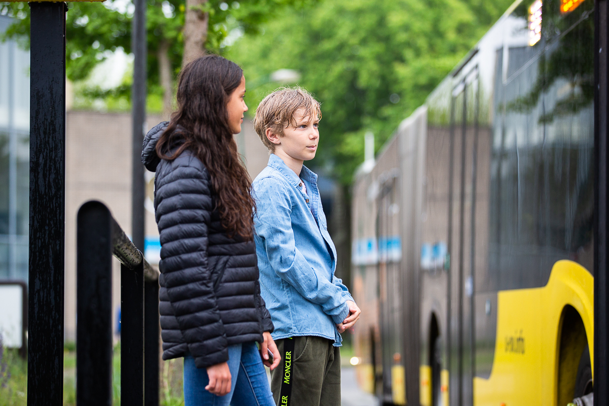 Meisje en jongen wachten op de bus