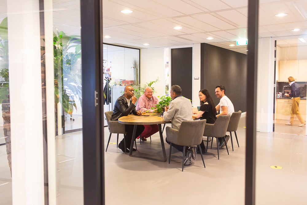 groep van vijf personen zit aan tafel