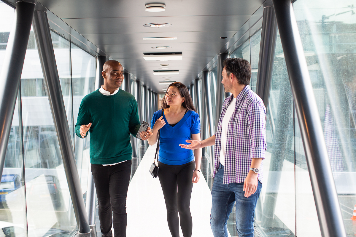 groep van drie personen loopt op loopbrug
